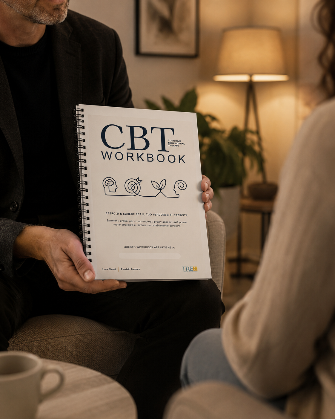 Psicologo psicoterapeuta mostra il CBT Workbook a una paziente durante una seduta per il trattamento dell'ansia, studio di Roma